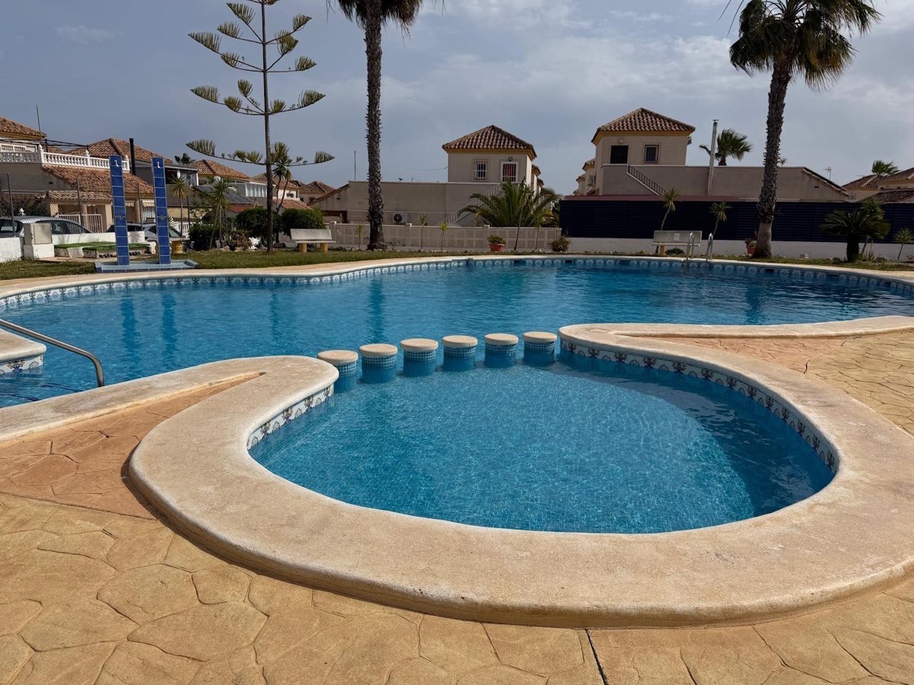 Detached villa with two residential units, a carport and a communal pool in a prime location