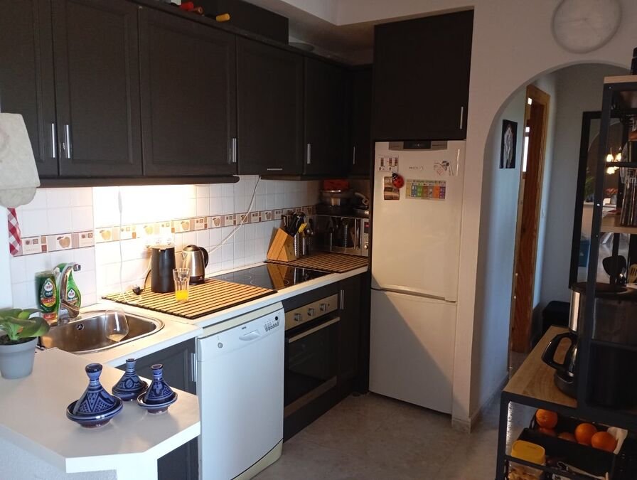 Appartement au rez-de-chaussée comprenant 2 chambres, 1 salle de bains, une place de parking et une piscine commune