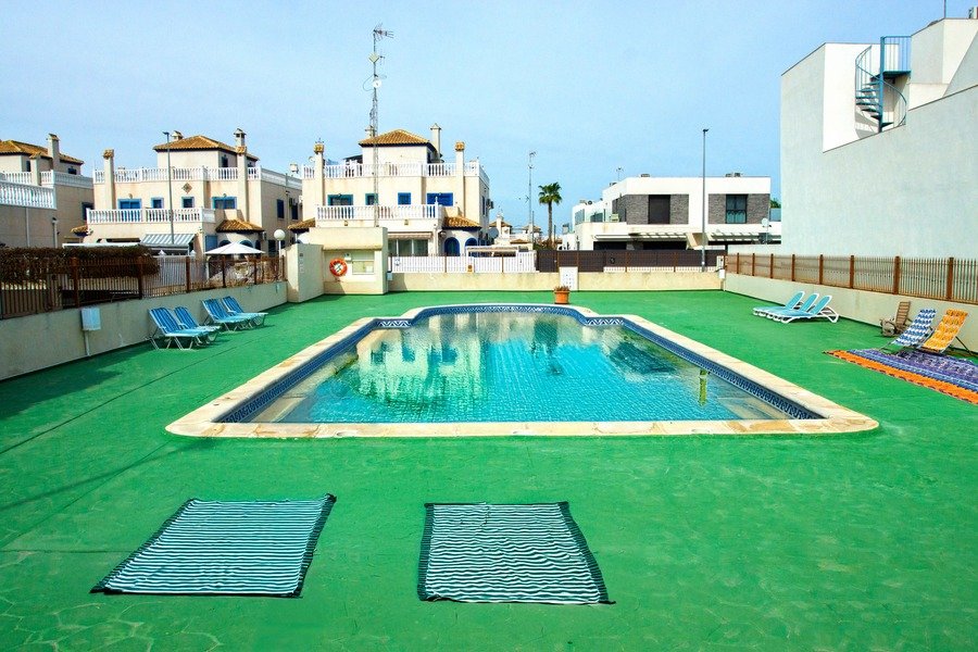 Appartement au rez-de-chaussée comprenant 2 chambres, 1 salle de bains, une place de parking et une piscine commune